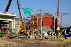 Demolition work on Zhongxiao Bridge North Gate ramp in Taipei city with construction fences and distant view of Taipei North Gate and Zhongxiao West Road