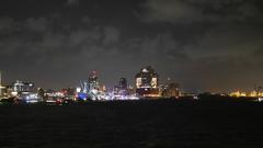 Elbphilharmonie in Hamburg Harbor at night with illuminated buildings and reflections on water