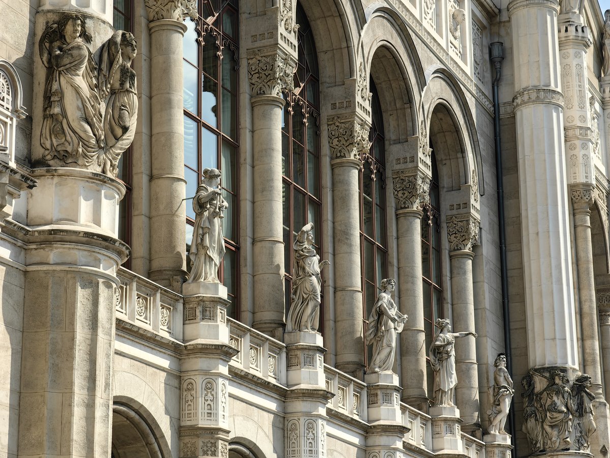Exterior view of Vígadó in Budapest at dusk with illuminated ornate façade