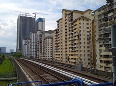 Taman Miharja Apartment buildings in Kuala Lumpur, Malaysia with trees in the foreground under a clear blue sky