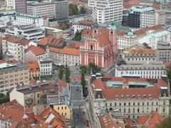 Overview of Prešeren Square, Franciscan Church, and Tromostovje (Three Bridges) in Ljubljana from Castle Hill
