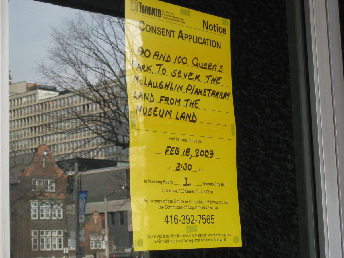 Yellow paper sign on window door of The McLaughlin Planetarium saying 'to sell the land'