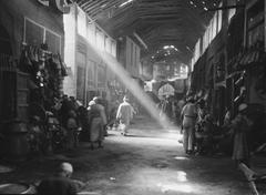 Historic black and white photograph of a bustling market in Iraq, 1932
