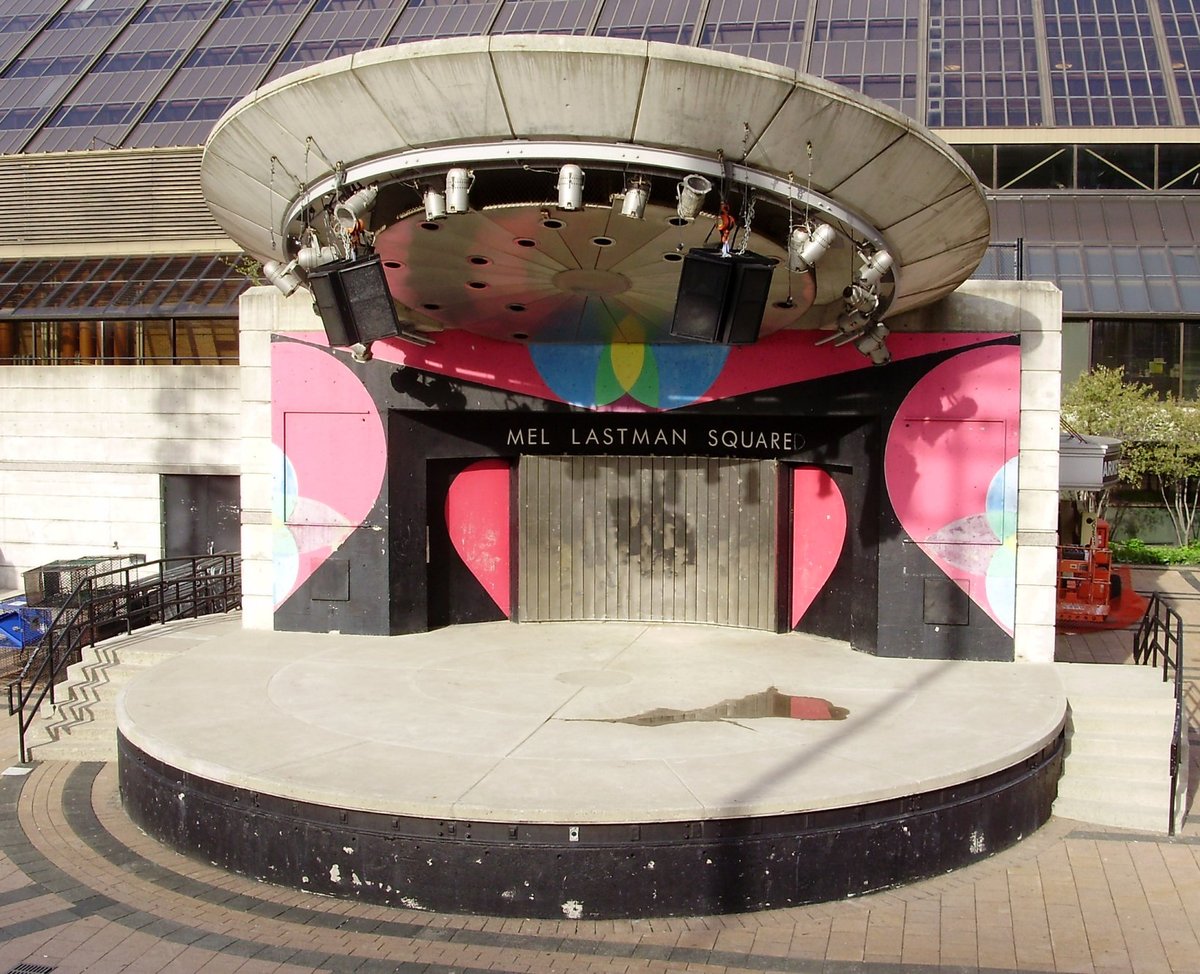 Performance stage at Mel Lastman Square in North York with graffiti on 'square' sign