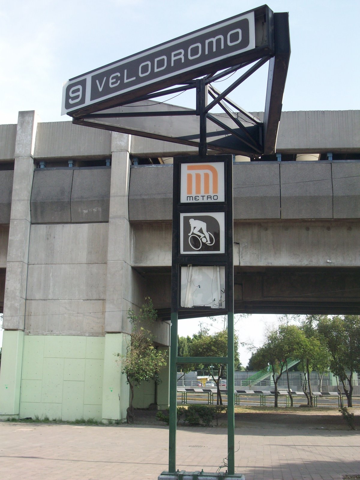 Velódromo Station sign with trees and blue sky background
