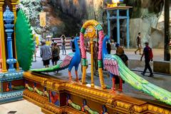 Peacock statue at Batu Caves with blue sky background