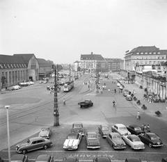 1955 view of Station Square in Karlsruhe showing cars, trams, trucks and buildings