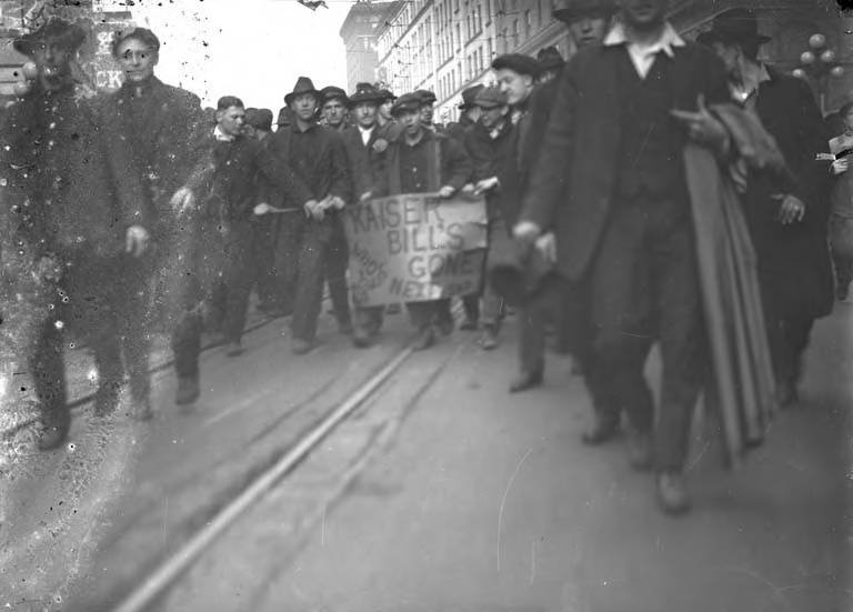 Group of men holding a sign that reads Kaiser Bill's gone Who's next in Seattle around 1917-1920