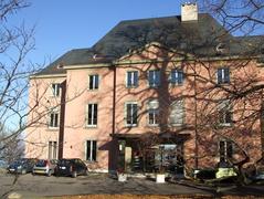 Villa Barton in Geneva with classical architecture surrounded by trees and a garden