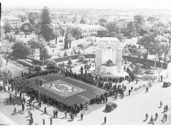 Crowd inspecting floral carpet and flowers on War Memorial at Kintore Avenue and North Terrace corner during Flower Day 1936