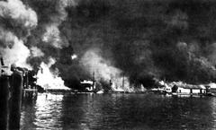 Burning Cavite Navy Yard after Japanese air attack on December 10, 1941 with explosions and torpedo-loaded barge on fire