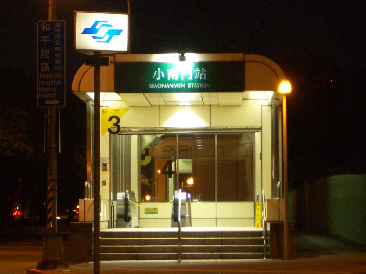 Night view of Exit 3 at Taipei MRT Xiaonanmen Station with illuminated signs and quiet street