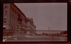 Equestrian statue of General Joseph Hooker in front of Massachusetts State House with iron fence and eagle-topped pillar