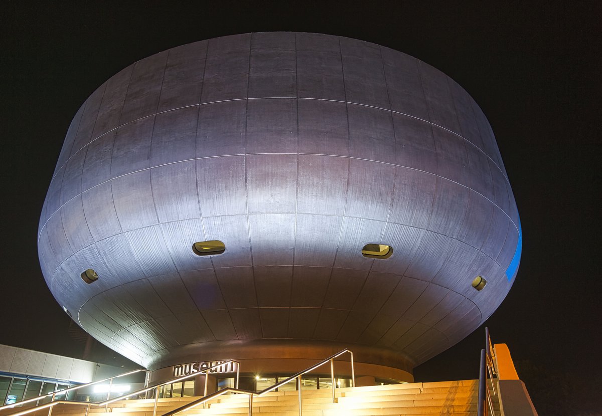 Exterior of BMW Museum at dusk with modern architecture and illuminated windows