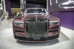 Front view of maroon Rolls-Royce Phantom with chrome grille and Spirit of Ecstasy hood ornament at BMW Museum Munich indoors