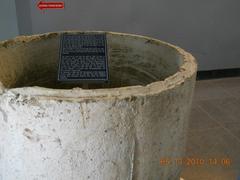Shallow well displayed in a museum with a plaque describing a tragic wartime event