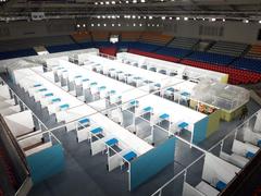 Ninoy Aquino Stadium converted into a COVID-19 isolation facility with rows of beds and medical equipment inside a large indoor sports complex