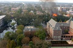 Fire burning in flooded New Orleans neighborhood after Hurricane Katrina with Notre Dame Seminary complex in foreground