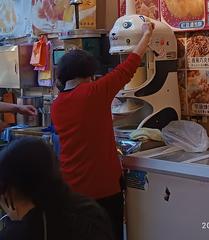 Elderly person working on ice shaver machine at dessert shop in Raohe Street Night Market, Taipei, Taiwan
