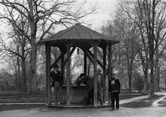 Man drinking water from a bucket at the Old Well at University of North Carolina in 1892