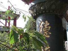 Hiking trail with a stone pillar of the Land God Temple and a hexagonal pavilion in the background at Qingtian Gang ridge