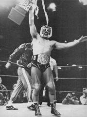 Tiger Mask holding WWF Junior Heavyweight Champion belt and trophy
