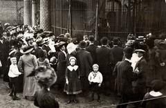 Visitors at Artis Zoo near the bear cage with a busy crowd and a photographer in Amsterdam 1910