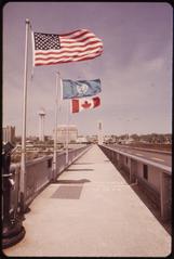 View of Rainbow Bridge spanning the Niagara River towards Canada with flags on the railing