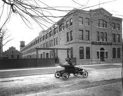 Ford Piquette Avenue Plant in Detroit, Michigan around 1906 with a Ford Model N driving east on Piquette Avenue