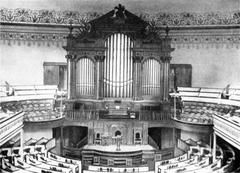 Interior view of Plymouth Church of the Pilgrims with wooden pews and ornate architectural details