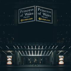Princess of Wales Theatre illuminated at night with lights and city buildings in the background