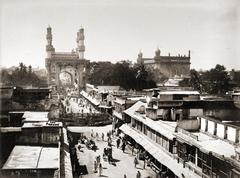 Historical street view of Hyderabad with the Char Minar in the background and Mecca mosque visible on the right