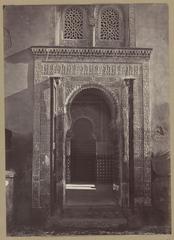 Historic black and white photo of La Mezquita in the Alhambra, Granada, showing architectural details from the 19th century