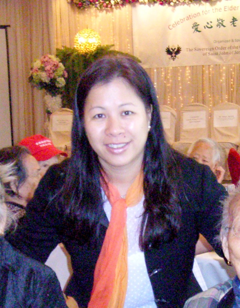 Portrait photo of a young woman with a subtle smile against a dark background
