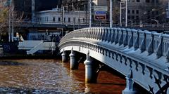 Queens Bridge crossing the Yarra River in Melbourne, a wrought iron continuous plate girder bridge with ornamental cast iron balustrades and arched bracing