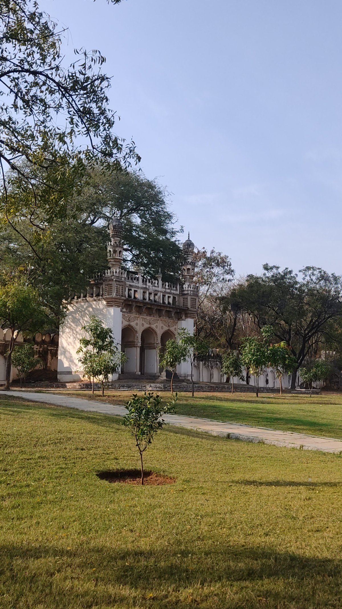 A mosque at the Qutb Shahi tombs complex with intricate architecture under a partly cloudy sky