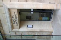 Front entrance of the Radcliffe Science Library with glass doors and tall stone pillars