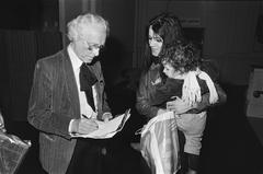 Carel Willink signing autograph for a mother and child at the opening of his exhibition at the Stedelijk Museum Amsterdam
