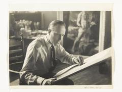 Portrait of Carel Willink drawing in his studio with his painting 'De kluizenaar' from 1938 in the background