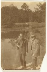 Black and white photo portrait of Carel Willink and E. du Perron standing in front of a pond at the Du Perron family estate in Gistoux, Belgium, 1926