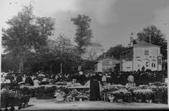 Flower market day in front of Nord Cemetery entrance with vibrant flower stalls and visitors
