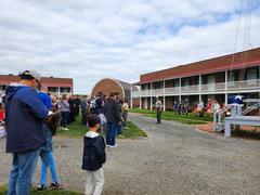 Fort McHenry Guard playing fife and drums during a rehearsal with a group of onlookers including rangers and uniformed guards