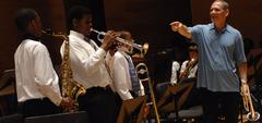 Children learning to play jazz instruments during an education outreach program