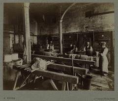 19th century photograph of the Gobelins Manufactory workshop in Paris, showing workers and tapestry equipment