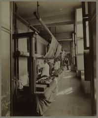 Weaving workshop at the Gobelins Manufactory in Paris with workers operating looms and threads in the 19th century