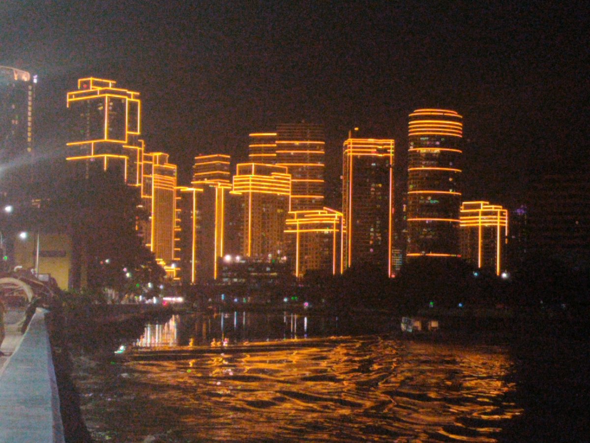 Night view of illuminated Rockwell Center buildings from Hulo, Mandaluyong City across Pasig River