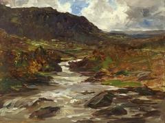 A scenic mountain stream flowing through rocky terrain with surrounding greenery