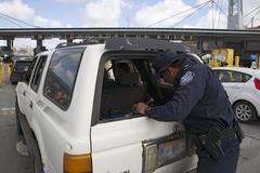 U.S. Customs and Border Protection officer inspecting vehicle at San Ysidro border crossing