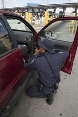 U.S. Customs and Border Protection officer inspecting vehicles at San Ysidro border crossing