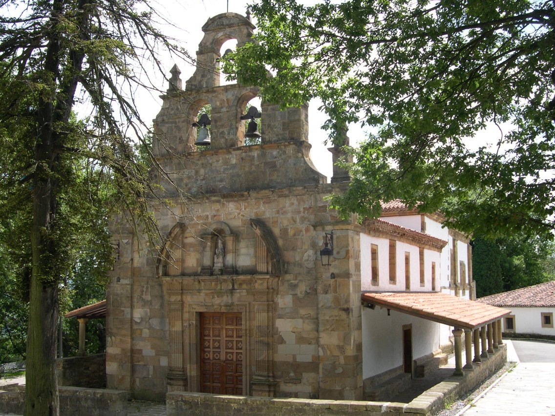 Traditional church building surrounded by lush greenery in Llangréu, Asturias